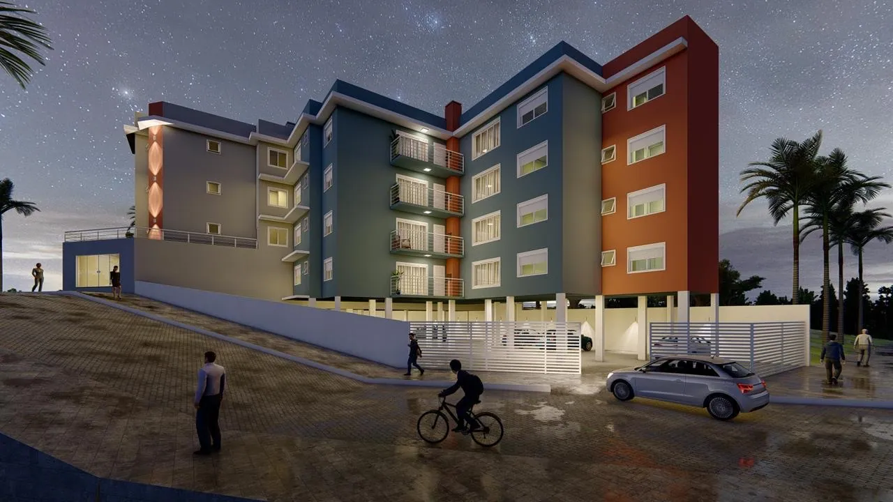 Fachada do São João Residencial à noite, com as lojas do térreo iluminadas, no Jardim Algarve em Alvorada
